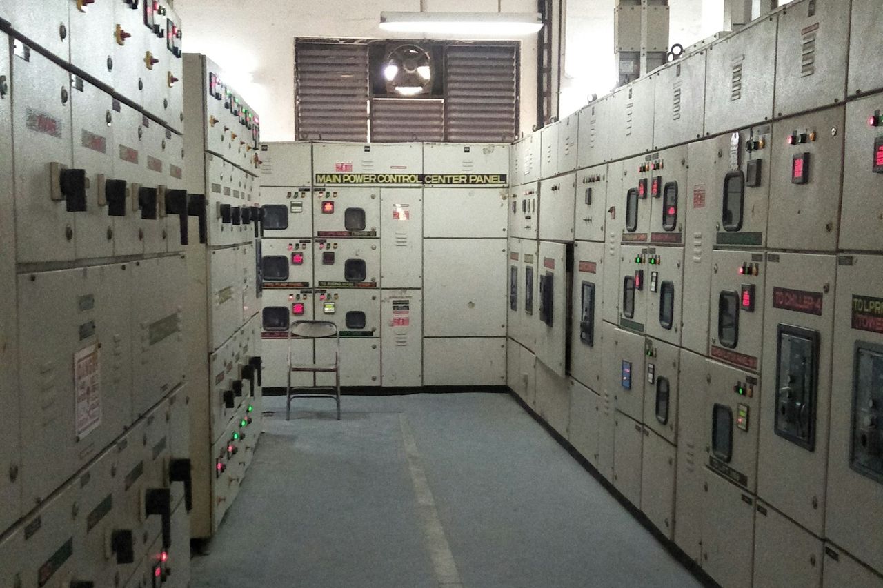 Rows of switchgear panels down both sides of a power control room.